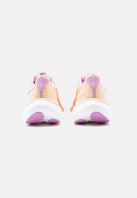 Ζευγάρι πορτοκαλιών και μωβ παπουτσιών τρεξίματος, που φαίνεται από πίσω, με λευκές μεσαίες σόλες και μοβ λεπτομέρειες πέλματος σε λευκό φόντο.