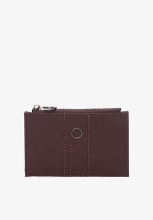 Burgunderrødt pung lavet af glat materiale med lynlåslukning, syninger og en cirkulær pynt foran.