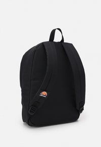 Sort rygsæk med polstret ryg, justerbare stropper og logopatch. Glat stofstruktur, rektangulær form og minimalistisk design.