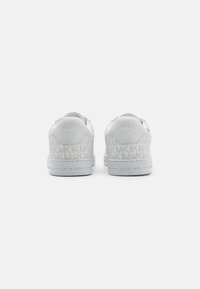 Des baskets blanches avec un tissu à motif arborant le logo "MK", des semelles en caoutchouc lisses et un col rembourré pour plus de confort. Un design simple, avec des accents minimalistes.