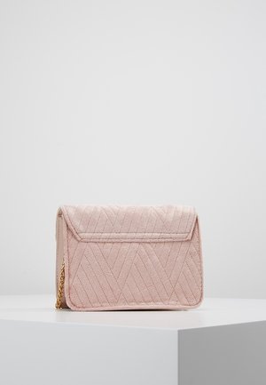 Gequilted roze handtas met een klepsluiting en een gouden kettingriem. Zachte suède textuur met een chevronpatroon op het oppervlak.