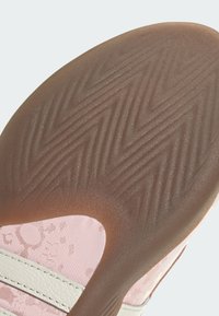 Εξωτερική σόλα παπουτσιού με σχέδιο ψαροκόκκαλο, από καφέ καουτσούκ και ροζ υφασμάτινες λεπτομέρειες με διακριτικό λουλουδάτο σχέδιο και κρέμ ρίγες.