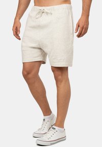 Pantaloni shorts in misto cotone grigio chiaro con elastico in vita e cordoncino. Presentano tasche laterali e un dettaglio con logo sull'orlo.