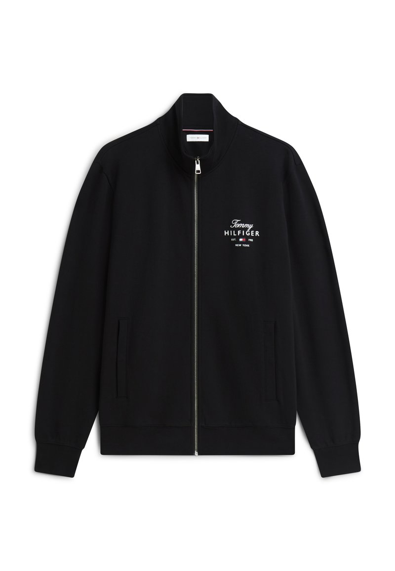 Schwarze Reißverschlussjacke mit Stehkragen, zwei Fronttaschen und weißem Tommy Hilfiger Logo sowie Schriftzug auf der linken Brustseite.