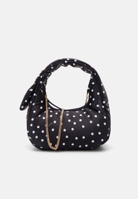Czarna torebka materiałowa o zaokrąglonym kształcie, białe kropki i złoty łańcuszek jako pasek. Miękka tekstura z marszczonym detalem na górze.