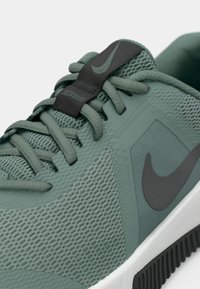 Roheline sportlik king, millel on tekstureeritud võrkülemus, mustad aktsendid, silmapaistev Nike logo ja kontrastne valge sola. Ka paelad on rohelised.