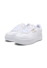 Baskets blanches en cuir avec une semelle plateforme texturée, design à lacets, et accents en or sur le côté. Comprend une languette et un col rembourrés.