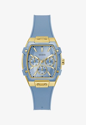 Mėlynas silikono laikrodis su kvadratiniu auksiniu korpusu, trimis papildomomis dalimis, tekstūruota apyranke ir "GUESS" logotipu ciferblate. Auksinės detalės ir rodyklės.