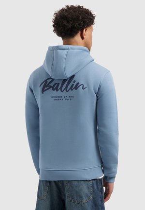 Lichtblauwe hoodie met een trekkoordkap, voorzien van een grote donkerblauwe grafische tekst op de achterkant. Gemaakt van zachte stof met geribde manchetten.