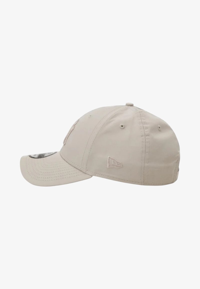 Berretto da baseball beige con visiera curva, occhielli di ventilazione e piccolo logo del marchio ricamato sul pannello laterale.