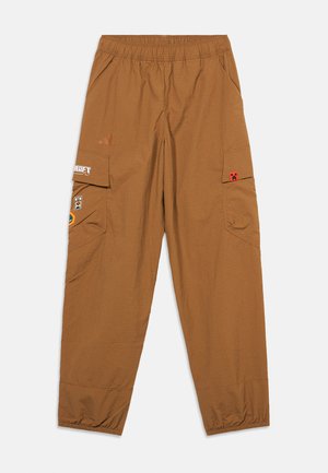 Braune Cargo-Hosen mit elastischem Bund und elastischen Bündchen sowie videospielbezogenen Aufnähern auf den Taschen, flach auf weißem Hintergrund ausgelegt.