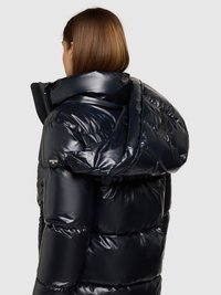 Prešívaná bunda z lesklého čierneho materiálu s vysokým golierom a kapucňou. Má bočné vrecká a logo pri ramene.