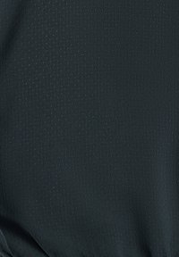 Gros plan d'un tissu foncé avec un motif discret de points, montrant la texture et les détails du tissage.