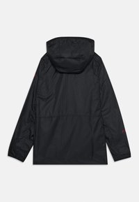 Zwarte hoodie gemaakt van soepel, lichtgewicht materiaal. Heeft een ontspannen pasvorm met elastische manchetten en een klein rood logo op de mouw.