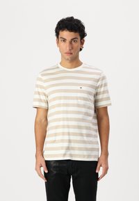 Striped T-shirt in beige and white, cotton material, short sleeves, crew neck, featuring a small logo on the left chest pocket.