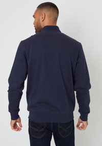 Marineblaue Sweatshirt mit hohem Kragen, gerippten Bündchen und Saum. Glatte Textur mit einem schlichten Design und ohne sichtbare Aufdrucke oder Logos.
