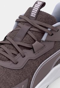 Brune mesh sneakers med grå accenter, der har en tekstureret overdel, flade snørebånd og en hvid sål. De har en brandet tunge for synlighed.