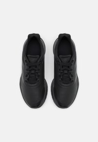 Scarpe sportive nere con tomaia sintetica liscia, punta arrotondata, dettagli texturizzati e chiusura con lacci con un branding discreto.