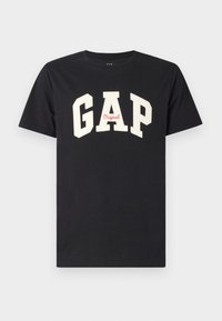 Fekete pamut póló, amelyen merész, fehér betűk írják "GAP" és piros színben a "Original" szó található alatta. Klasszikus kerek nyakkivágással.