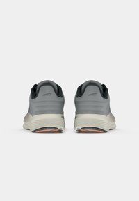 Gray athletic shoes with a smooth upper, gray mesh fabric, and a white cushioned sole. Features a treaded black outsole with orange accents.