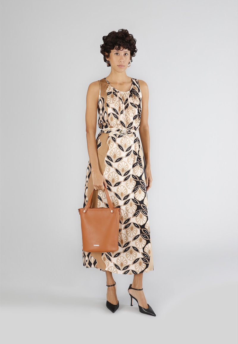 Maxiklänning med blommönster i beige, svart och brunt; axelremmar, åtsittande midja, kombinerad med en brun läderväska och svarta klackar.