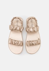 Goldene Rutschen-Sandalen mit zwei gerafften Riemen, glattem synthetischem Obermaterial, flacher Sohle und einem entspannten Design für einfaches Tragen.