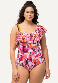 Fuksiavärinen uimapuku, jossa on röyhelökaula-aukko, abstrakti kukkakuosi vaaleanpunaisessa, oranssissa ja valkoisessa, sekä kontrastiväriset olkaimet.