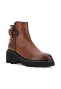 Ruskea nahkainen nilkkaboots mustalla paksulla pohjalla, sivussa solkihiihtävä ja lohkarekorko, valkoisella taustalla.