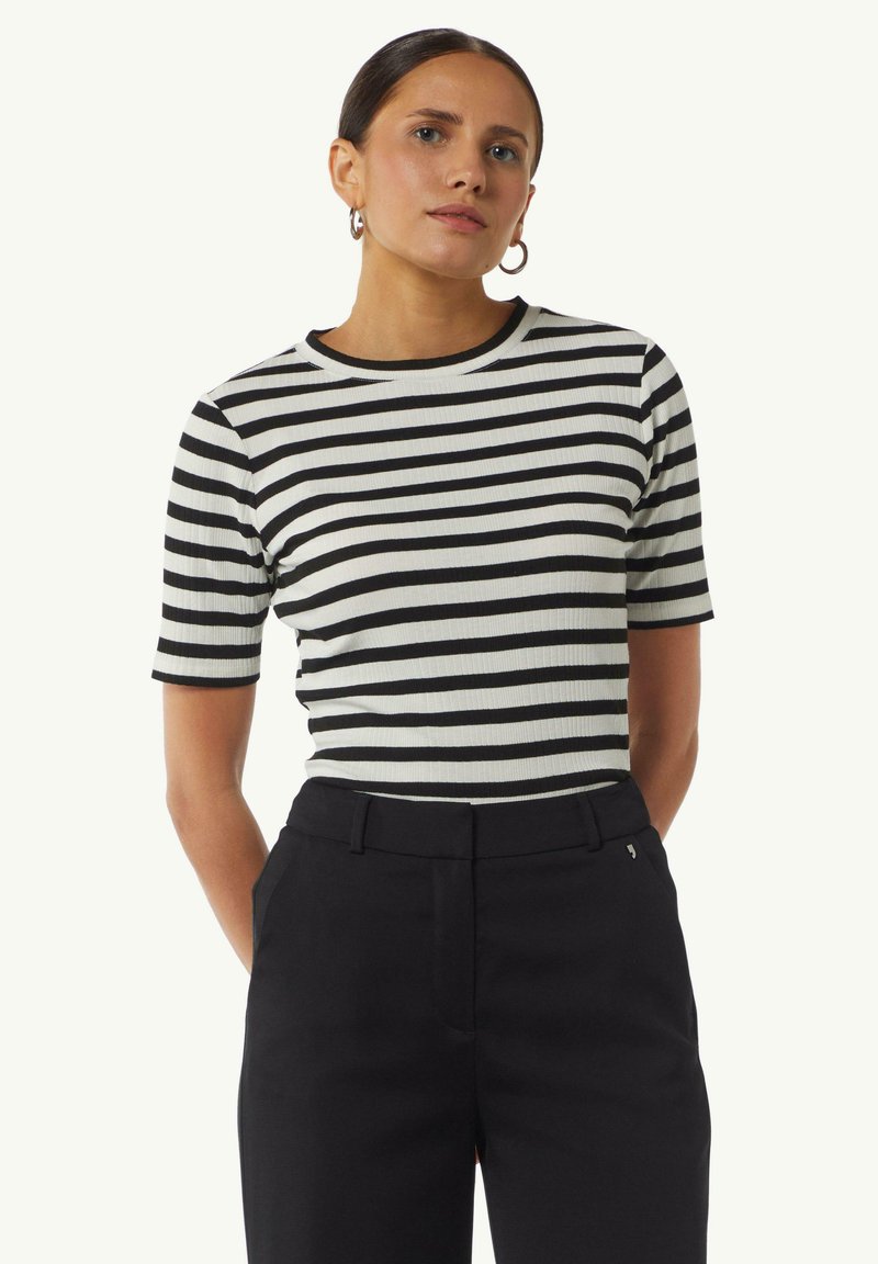 Zwart-wit gestreepte top met korte mouwen, een geribbelde textuur en ronde halslijn, gecombineerd met hoge zwarte broek.