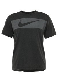 Camiseta gris oscuro de algodón suave, con una franja horizontal de patrón de malla y un logo negro de Nike en el pecho.
