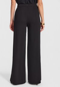 Szerokie czarne spodnie z gładkiego materiału, z wysokim stanem, tylnym zamkiem błyskawicznym oraz dwoma pionowymi plisami dla dodatkowego efektu.