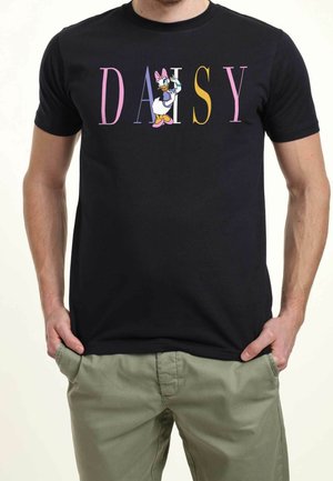 Czarna koszulka z kolorowym napisem "DAISY" oraz ilustracją Daisy Kaczor zamiast litery "I", noszona przez osobę z rękami w kieszeniach.