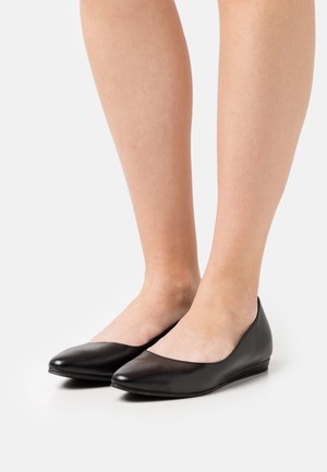 Black leather ballerina flats with a low wedge heel. Rounded toe design and smooth texture, with no visible patterns or embellishments.