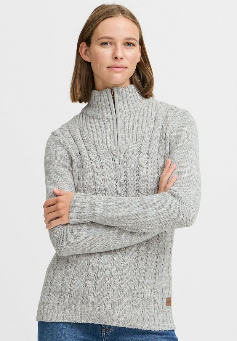 Helle graue Pullover aus Kabelstrick mit hohem Kragen und halblangem Reißverschluss. Besitzt gerippte Bündchen und Saum, gefertigt aus strukturiertem Strickstoff.