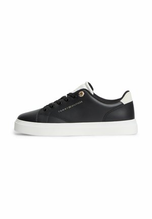 Baskets basses noires avec semelle blanche, languette de talon blanche, lacets noirs et logo "Tommy Hilfiger" doré sur le côté.