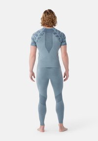 Haut de sport bleu et leggings, avec des motifs texturés, une coupe ajustée et une construction sans couture. Tissu léger et respirant.