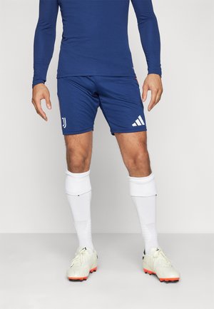 Blå atletisk langærmet trøje og shorts med Juventus-logo og hvide Adidas-striber, parret med hvide sokker og lyse letvægtsstøvler med orange accenter.