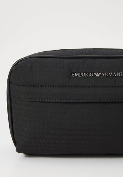 Must musta kosmeetikakott, millel on reljeefne Emporio Armani logo ja hõbedased detailid. Omab siledat tekstuuri ja voolujoonelist disaini.