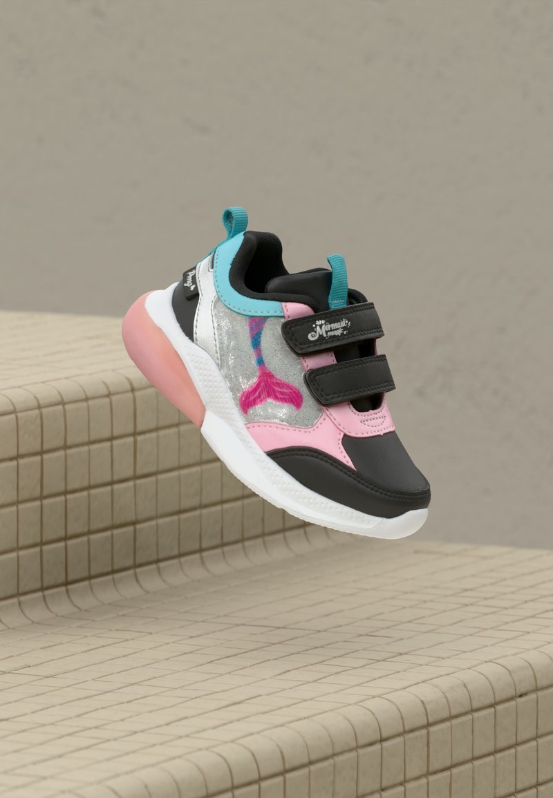 Kindersneaker mit rosa, schwarz, türkisfarbenen Akzenten, glitzernden silbernen Paneelen, Mermaidschwanz-Design und doppeltem Klettverschluss, schwebend über gefliesten Stufen.
