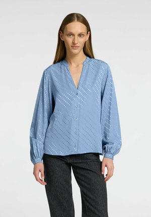 Lichtblauwe blouse met een relaxte pasvorm, knoopsluiting aan de voorkant en een lichte glans. Heeft balloonmouwen en een patroon van verhoogde stippen door het hele shirt.