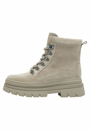 Bottine en suède beige avec une semelle épaisse à traction, dotée d'œillets en métal, de lacets ronds et d'une languette en boucle au niveau du talon.