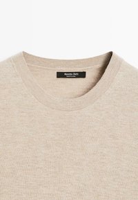 Maglione beige con scollatura rotonda e dettagli a costine. L'etichetta riporta "Massimo Dutti" e "Made in China."