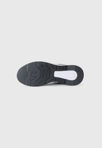 Zwart-witte sneakerzool, vervaardigd uit een getextureerd rubbermateriaal met een zigzagpatroon, ronde neus en een centrale witte acccent.