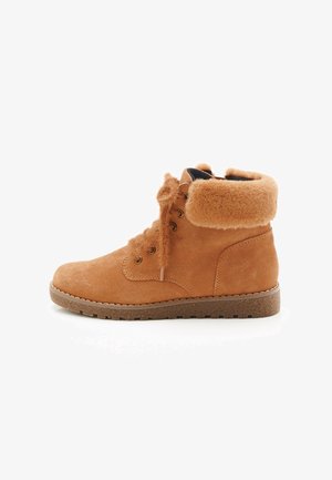 Stivaletto in suede marrone con fodera in pelliccia, lacci soffici e suola in gomma, mostrato di lato su uno sfondo bianco.