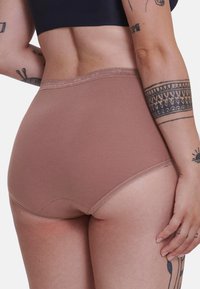Hoge taille, lichtbruine ondergoed met een zachte textuur en elastische tailleband. Subtiele stikdetails langs de randen.