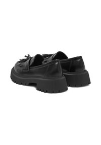 Čierne kožené mokasíny s masívnou gumovou podrážkou, majú okrúhlu špičku, dekoratívne franžové akcenty a nízky strih so zapínaním na skĺzanie.