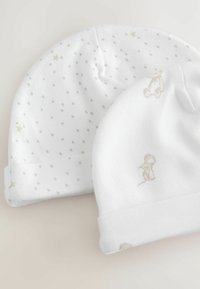 To hvide babyhuer lavet af blødt stof. Den ene har et prikket mønster med stjerner, mens den anden har et lysebrunt abe-motiv.
