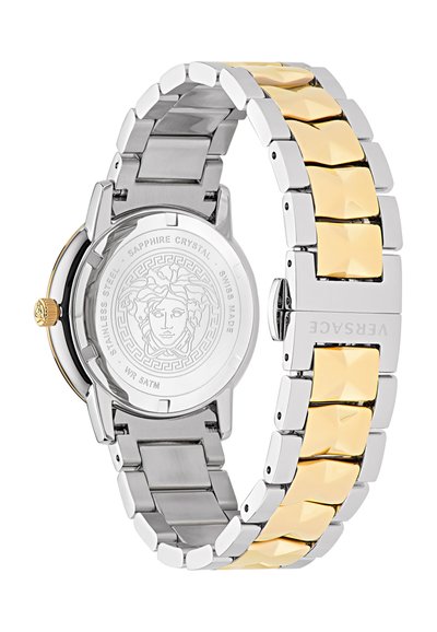 Hõbedast ja kuldsetest roostevabast terasest kell, millel on segast metallist rihm, millel on tekstuuriga kuldne aktsent ja ümmargune graveeritud tagakülg.