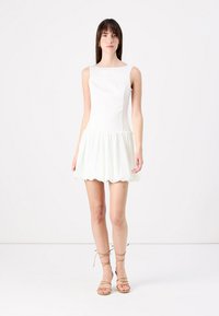 Rochie albă fără mâneci, cu un corset ajustat și fustă evazată, plisată. Textură fină, cu detalii subtile de cusătură. Asortată cu sandale bej cu bretele.