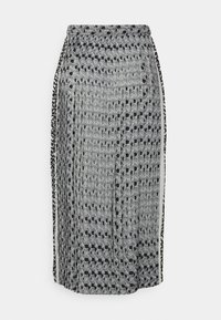 Falda de estampado en blanco y negro con diseño plisado, que presenta formas geométricas y una abertura lateral, fabricada con un tejido ligero.